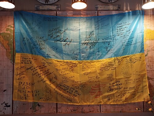 Ukrainian flag with signatures of soldiers of the Armed Forces of Ukraine and famous people at "Komora - the first dumpling factory" in Poltava,18.05.2025