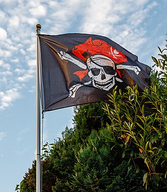 Flying black pirate flag with white skull and crossbones