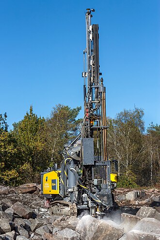 An Epiroc SmartRoc T40 surface drill rig drilling blast holes for dynamite into granite rocks at a construction site for a new house in Brastad, Sweden.