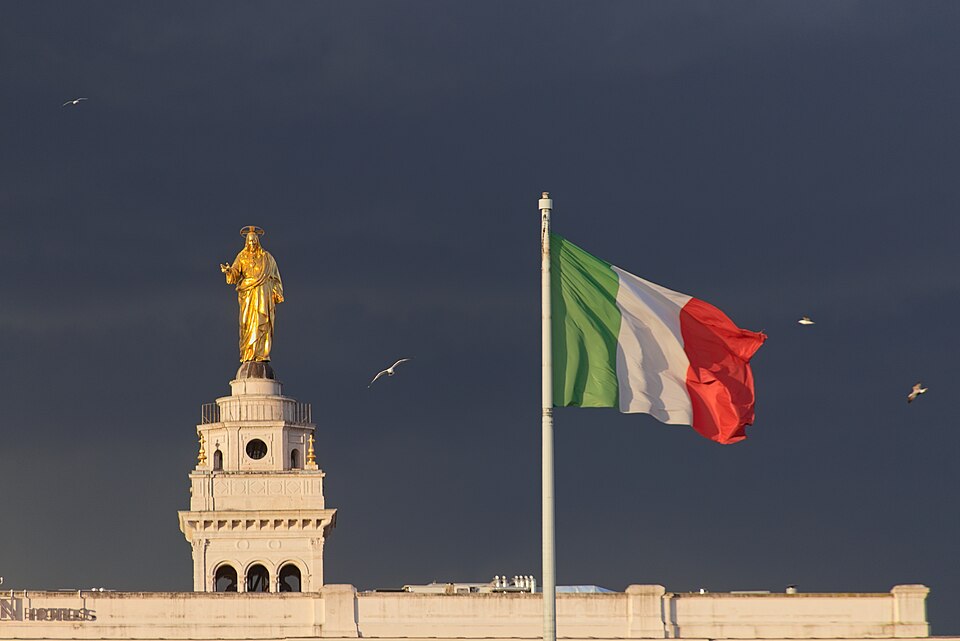 Flag of Italy, in the background Basilica Del Sacro Cuore, Rome, Italy
