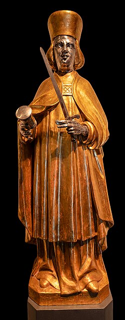 This sculpture shows Saint Damian, one of the twin brothers Cosmas and Damian, located at the entrance of the Essen Cathedral Treasury. The figure is made of wood, gilded and silvered. It dates from 1715 and was donated by Princess Bernhardine of Hesse-Rheinfels.