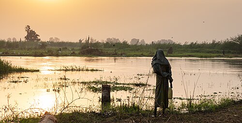 Mundari woman observing the White Nile after sunrise, Terekeka, South Sudan.