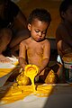 Baby playing with yellow paint