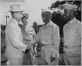 "After inspecting a regiment of Negro artillerymen during a visit to Hawaii, Under Secretary of War Robert P. Patterson congratulates Col. Chauncey M. Hooper,...commander of the unit, while Lt. Gen. Robert C. Richa(...) - NARA - 524377.gif