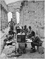 "A company of men has set up its office between the columns (Doric) of an ancient Greek temple of Neptune, built about 7 - NARA - 531170.jpg