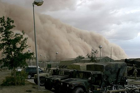 A massive dust storm cloud (haboob) is close to enveloping a military camp as it rolls over Al Asad, Iraq, just before nightfall on April 27, 2005.