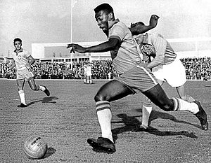 The great footballer Pelé dribbling past a defender