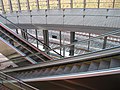 : Intérieur de la gare de Belfort - Montbéliard TGV en direction des voies, escalators et rampe l'accès aux quais